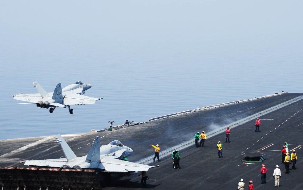 Avião militar dos Estados Unidos decola do porta-aviões USS George H.W. Bush no Golfo para missão no Iraque. Dois anos e meio depois da retirada americana, os jihadistas do EI conseguiram se apoderar de uma parte do noroeste do país — Foto: Lorelei Vander Griend/Marinha dos EUA/AFP