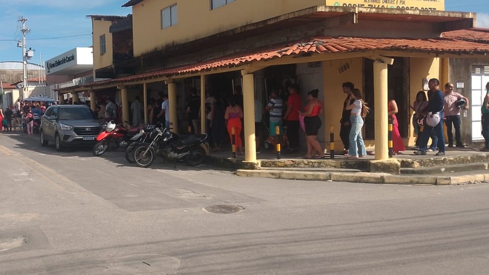 Fila de pessoas dobra a esquina esperando por atendimento. — Foto: Reprodução