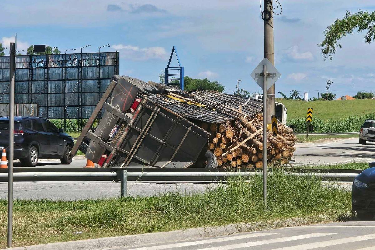 Caminhão com madeira tomba e interdita faixa na Rod. Floriano Rodrigues Pinheiro, em Tremembé