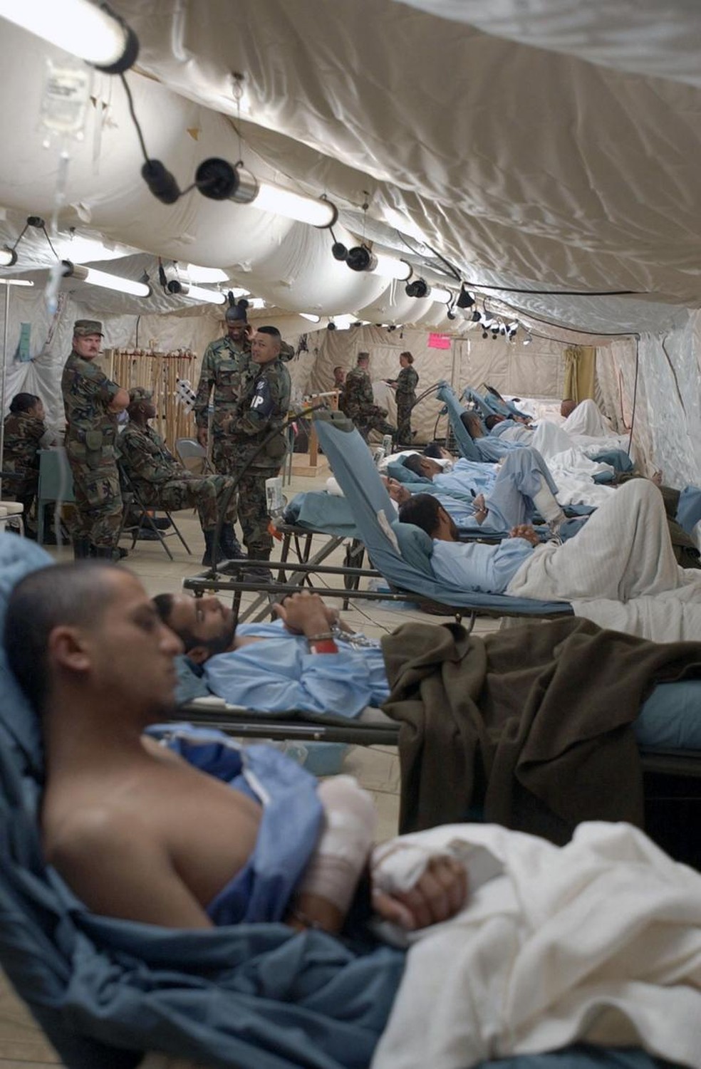 Havia uma instalação hospitalar em Camp X Ray, o Fleet Hospital Twenty, onde vários dos detidos foram levados na chegada a Guantánamo. Mesmo quando estavam nas macas, os prisioneiros permaneciam com pés e mãos algemados. — Foto: SHANE T. MCCOY/USMC via BBC