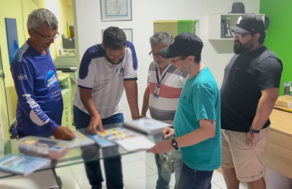 Grupo se reúne na gráfica diariamente em busca dos "santinhos" que faltam — Foto: Anthony Medeiros