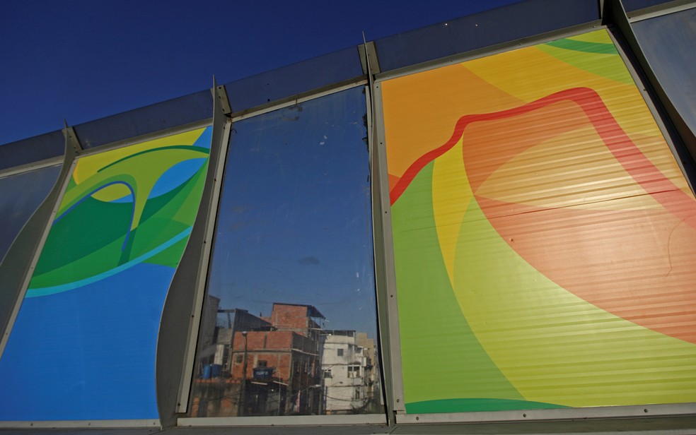 Posters dos Jogos Olímpicos Rio 2016 são colocados na Linha Vermelha, perto do complexo de favelas da Maré, que liga o Aeroporto Internacional do Rio de Janeiro com o centro e a zona sul da cidade  — Foto: Ricardo Moraes/Reuters