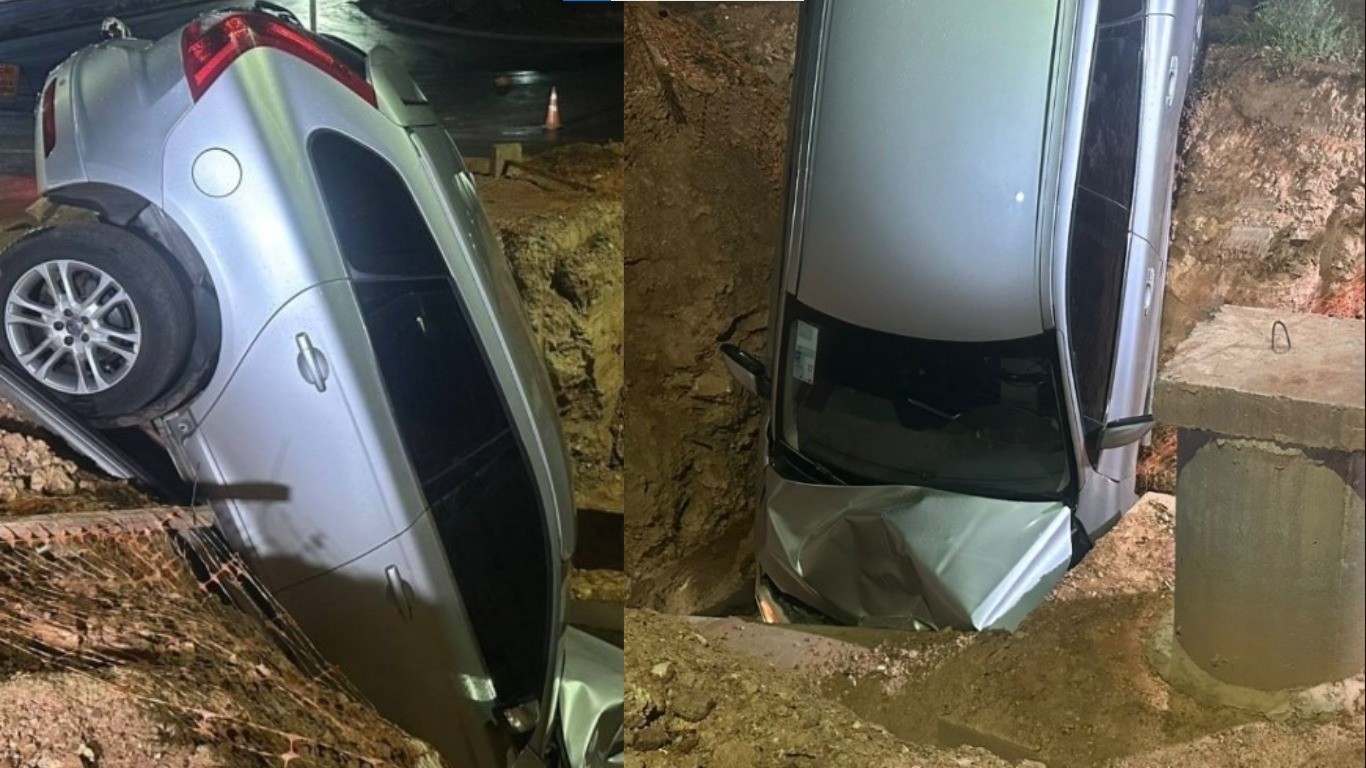 Carro de luxo cai em valeta de obra durante chuva em Cuiabá