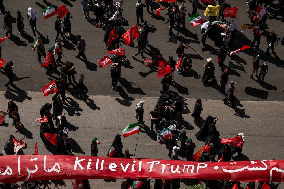 Pessoas em luto carregam uma faixa contra o presidente dos EUA, Donald Trump, enquanto se reúnem no dia do enterro do falecido Líder Supremo do Irã , o aiatolá Ali Khamenei — Foto: REUTERS/Alkis Konstantinidis