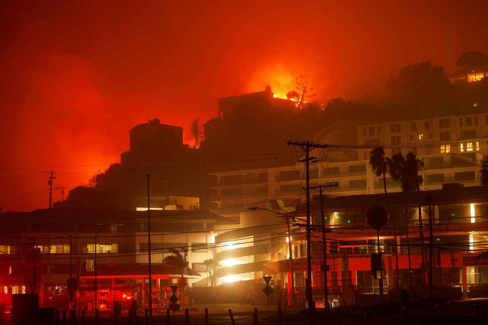 Edifícios e casas queimam em incêndio florestal em Pacific Palisades em Los Angeles em 7 de janeiro de 2025. — Foto: REUTERS/Mike Blake