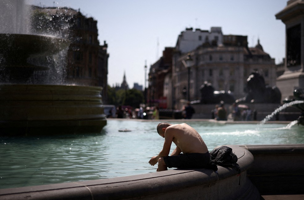 Um homem se refresca em uma fonte de água em Trafalgar Square, Londres, durante a onda de calor que assolou o Reino Unido, em julho de 2022, e teve temperaturas recordes no país.  — Foto: Reuters