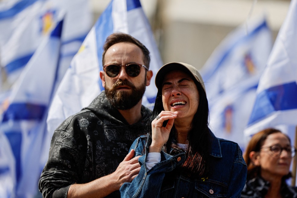 Mulher chora em Tel Aviv no momento da entrega de corpos de reféns israelenses, incluindo a família Bibas, pelo Hamas em 20 de fevereiro de 2025. — Foto: REUTERS/Ammar Awad