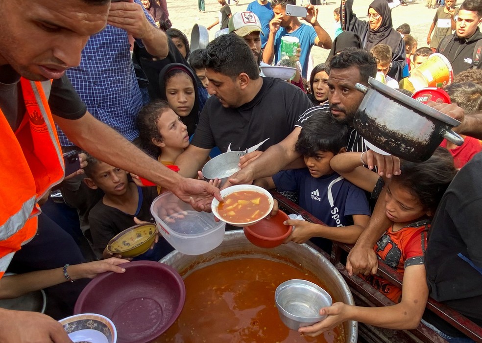 Palestinos desalojados por ataques de Israel fazem fila para conseguir comida em Rafah, no sul de Gaza — Foto: Mahmoud al-Masri/Reuters
