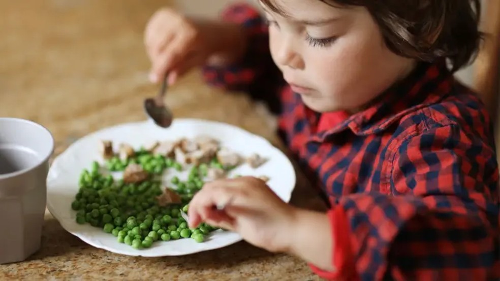 Criança com prato de comida — Foto: Getty Images