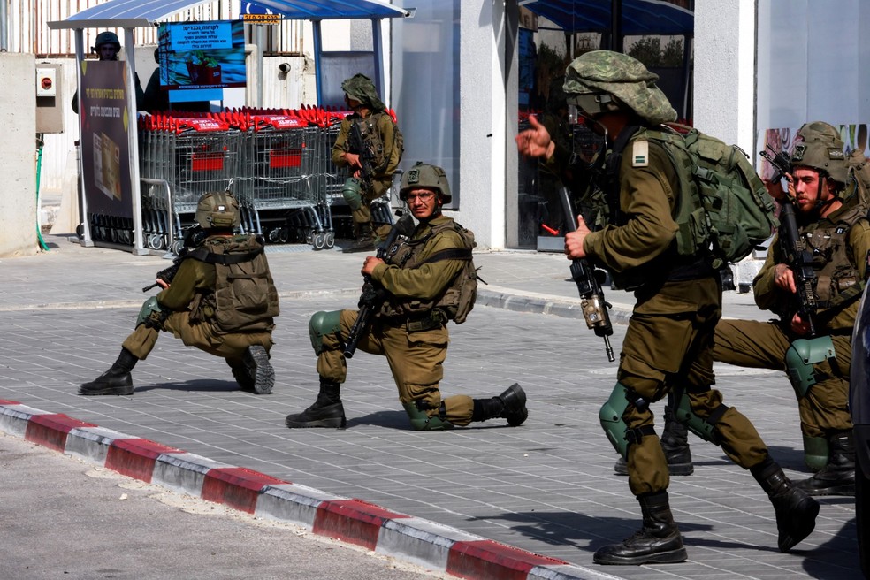 Soldados israelenses trabalham para proteger áreas residenciais após uma infiltração — Foto: Reuters