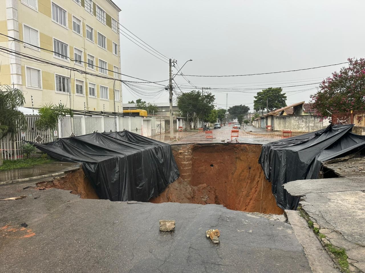 Cratera na Zona Sul de São José é coberta com lonas; moradores recebem cestas básicas e colchões