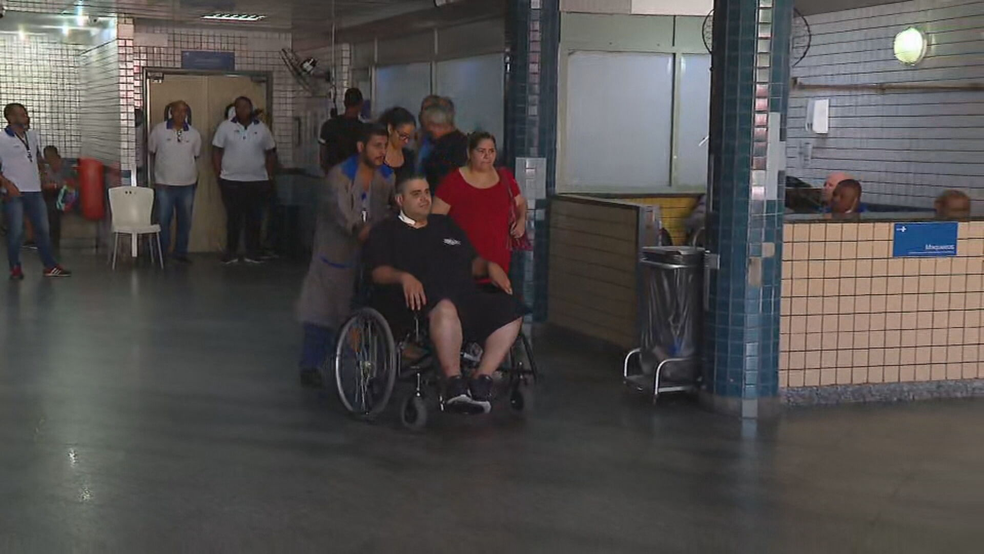 Em uma cadeira de rodas, Bruno Patrocino Bastos, deixa o Hospital Salgado Filho — Foto: Marcos Coelho/TV Globo