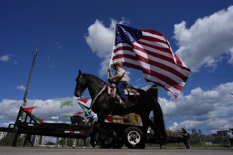 Participantes agitam bandeiras durante o desfile do Dia da Independência Mexicana de Pilsen, em Chicago — Foto: AP/Carolyn Kaster