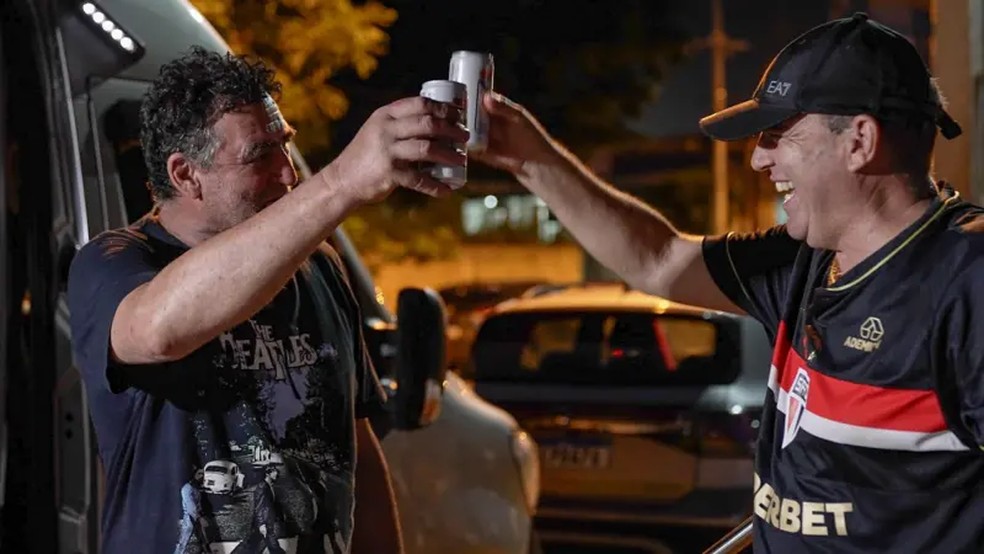 Antes de passarem a madrugada na fila, brasileiros organizaram churrasco com cerveja em frente ao centro que promove mutirão em Ciudad del Este — Foto: Fernando Otto/BBC