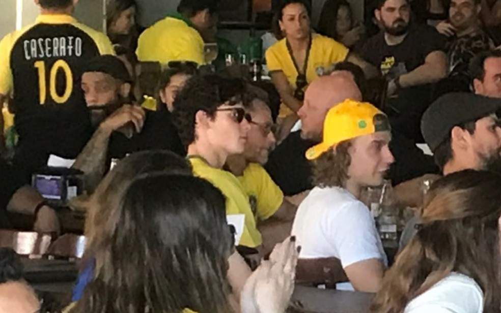 Com camisa da Seleção Brasileira e óculos, o cantor Shawn Mendes assiste ao jogo entre Brasil e México em um bar de Goiânia — Foto: Luciano Cabral/TV Anhanguera