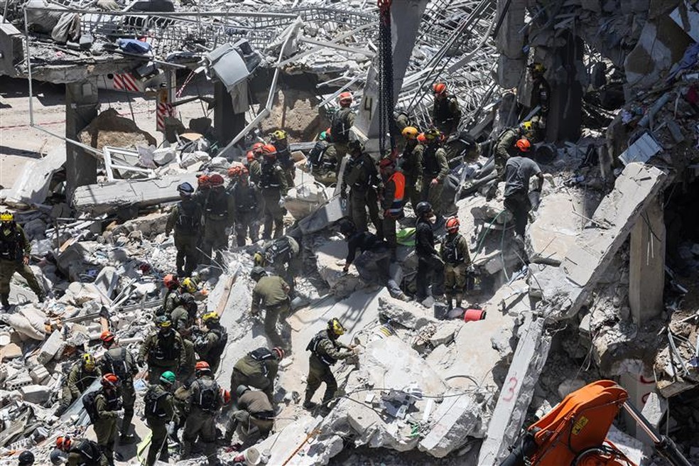 Equipe de resgate atua em local atingido por míssil iraniano, em Israel. — Foto: Ronen Zvulun/Reuters