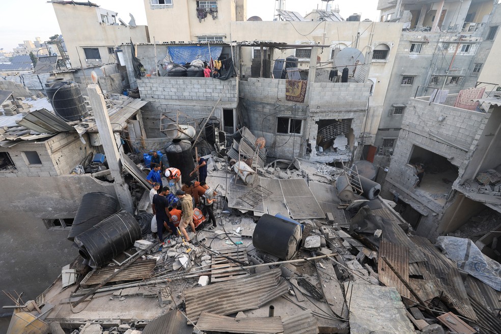 Palestinos recuperam corpo sob os escombros de uma casa atingida em um ataque israelense durante a noite, na Cidade de Gaza, em 29 de outubro de 2025. — Foto: Dawoud Abu Alkas/Reuters