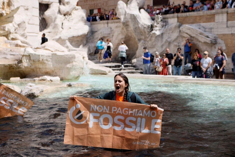 Ativista do clima segura uma faixa durante uma manifestao contra os combustveis fsseis em Roma. — Foto: Alessandro Penso/MAPS via REUTERS