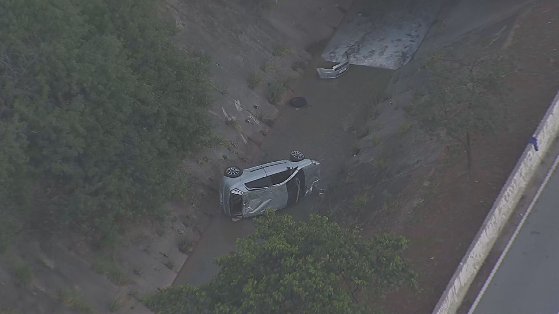 Carro capota e cai em córrego na Avenida Jacu-Pêssego, em Itaquera, Zona Leste de SP; jovem de 19 anos fica ferido