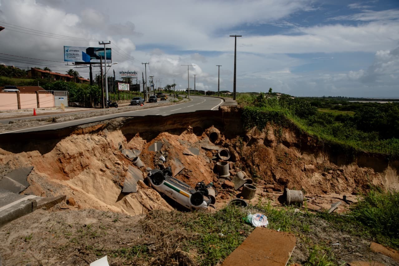 Estrada na Grande Fortaleza cede com forte chuva e engole carro e motos; uma pessoa morreu