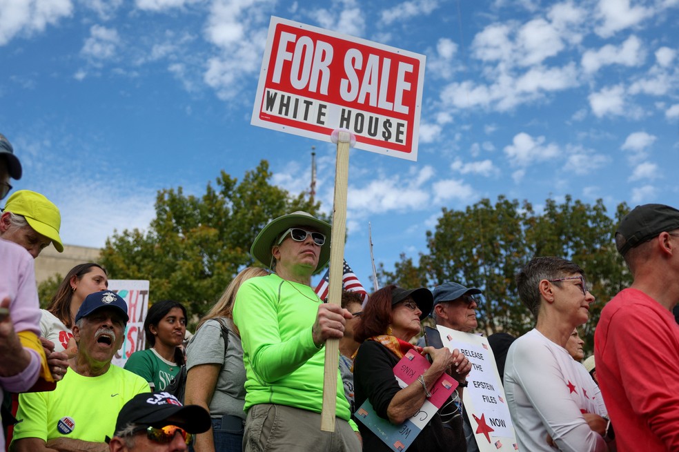 Um manifestante segura um cartaz durante o protesto “No Kings” contra as políticas do presidente dos Estados Unidos, Donald Trump, em Washington, D.C., em 18 de outubro de 2025 — Foto: REUTERS/Kylie Cooper