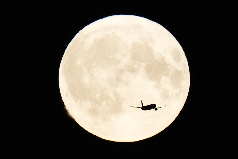 Um avião passa pela superlua sobre Copenhague, na Dinamarca. — Foto: AP