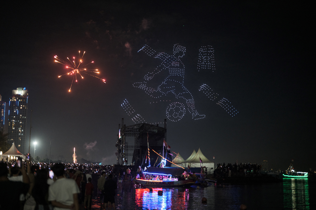 Show de drones ilumina o céu com uma cena de futebol antes dos fogos de artifício do Ano Novo na Praia Ancol, em Jacarta, Indonésia — Foto: Yasuyoshi Chiba/AFP