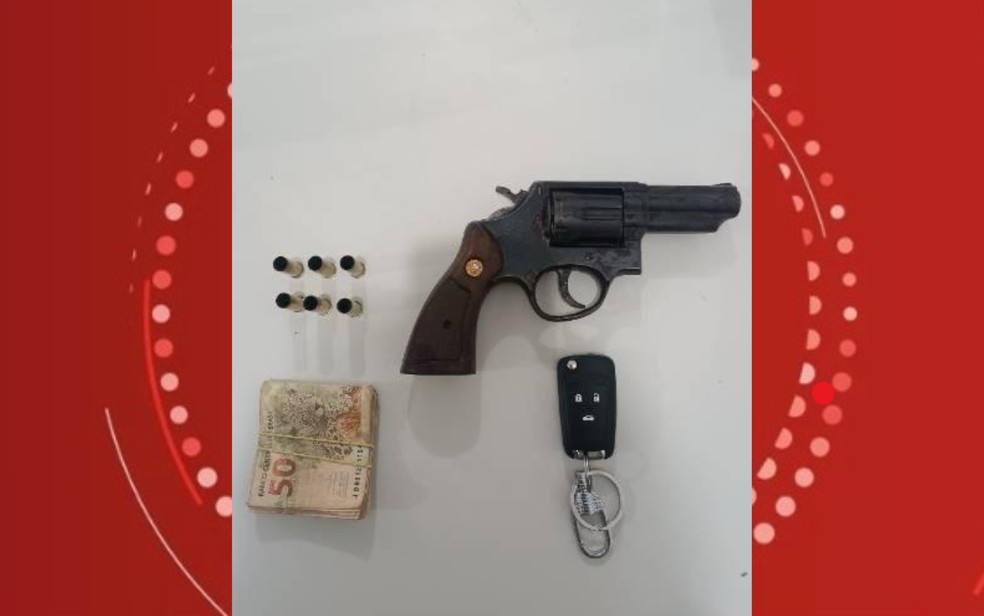 Uma arma, munições e dinheiro foram apreendidos com o suspeito do crime — Foto: Polícia Militar
