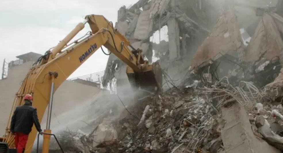 Equipes de resgate escavam os escombros de um prédio residencial em Teerã destruído por um ataque de Israel — Foto: BBC