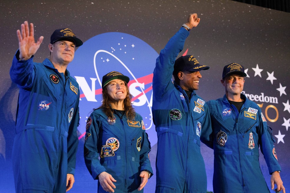 A tripulação da missão Artemis II, composta posa no palco um dia após o pouso no Oceano Pacífico, na Base Aérea Conjunta de Ellington Field, em Houston, Texas, EUA, em 11 de abril de 2026 — Foto: REUTERS/Lexi Parra
