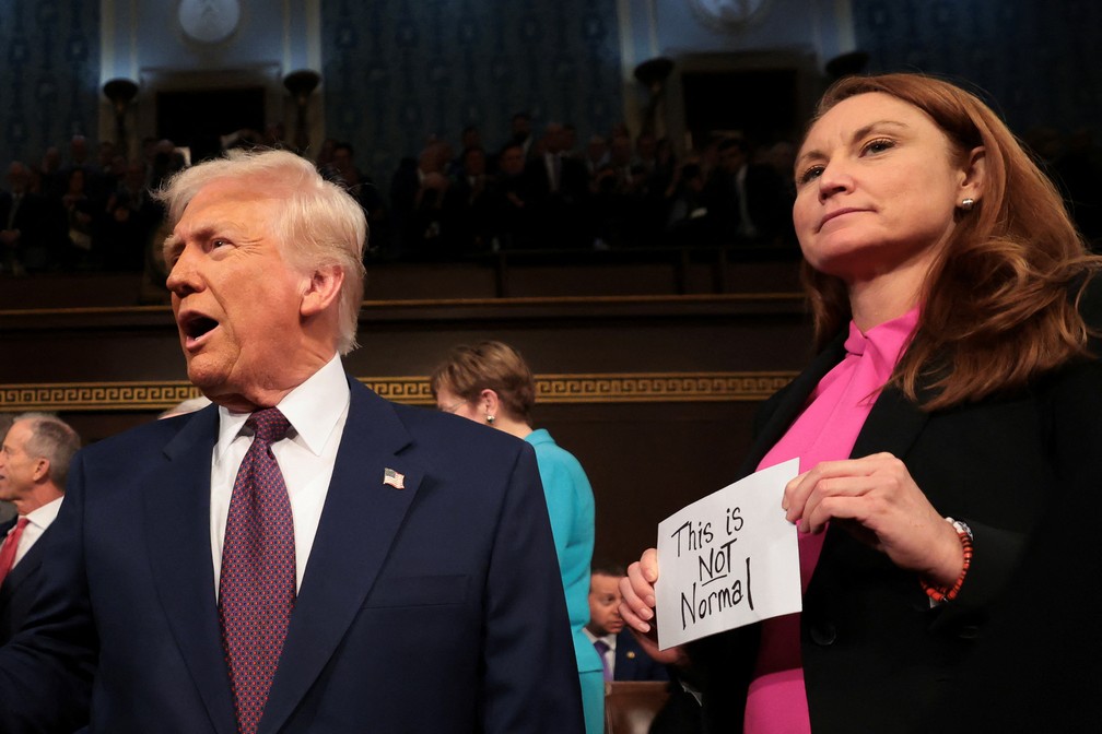 O presidente Donald Trump chega para seu discurso em uma sessão conjunta do Congresso enquanto a deputada Melanie Stansbury (D-NM) segura um cartaz com os dizeres "Isso não é normal" no Capitólio dos EUA em 4 de março de 2025, em Washington, DC. — Foto: Win McNamee/Pool via REUTERS