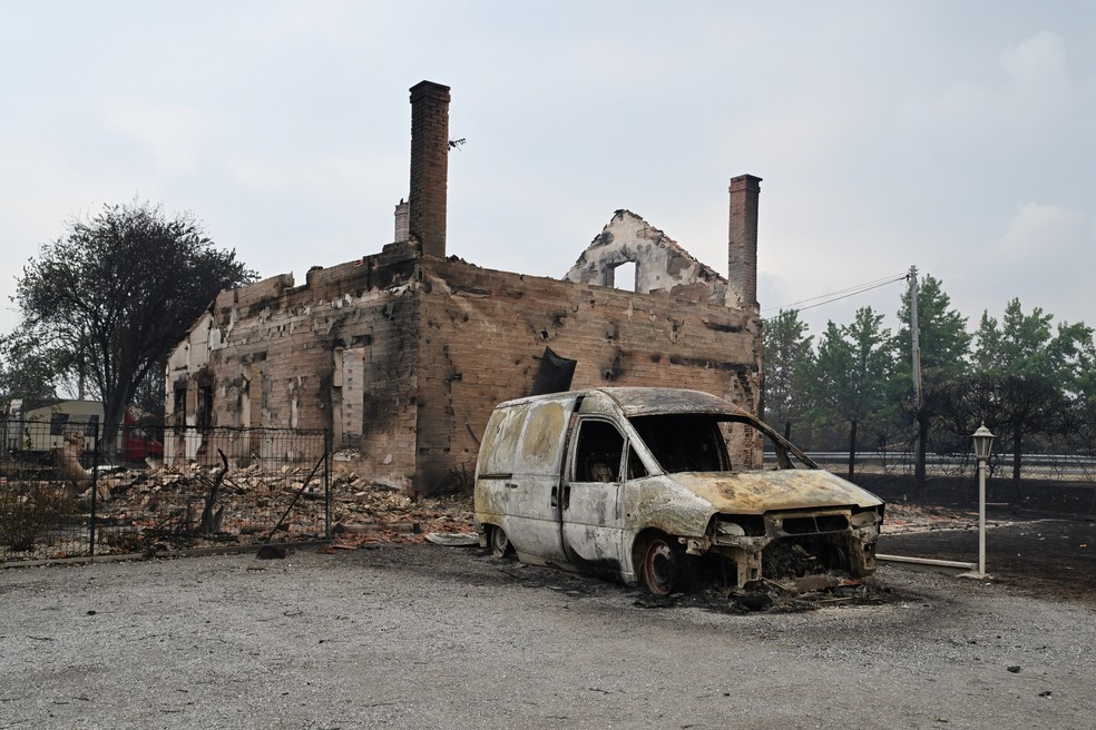 Casa e veículo destruídos por incêndio em Lanton, na região de Lège-Cap-Ferret, no sudoeste da França, neste sábado (25). — Foto: Emma Da Silva/AP Photo