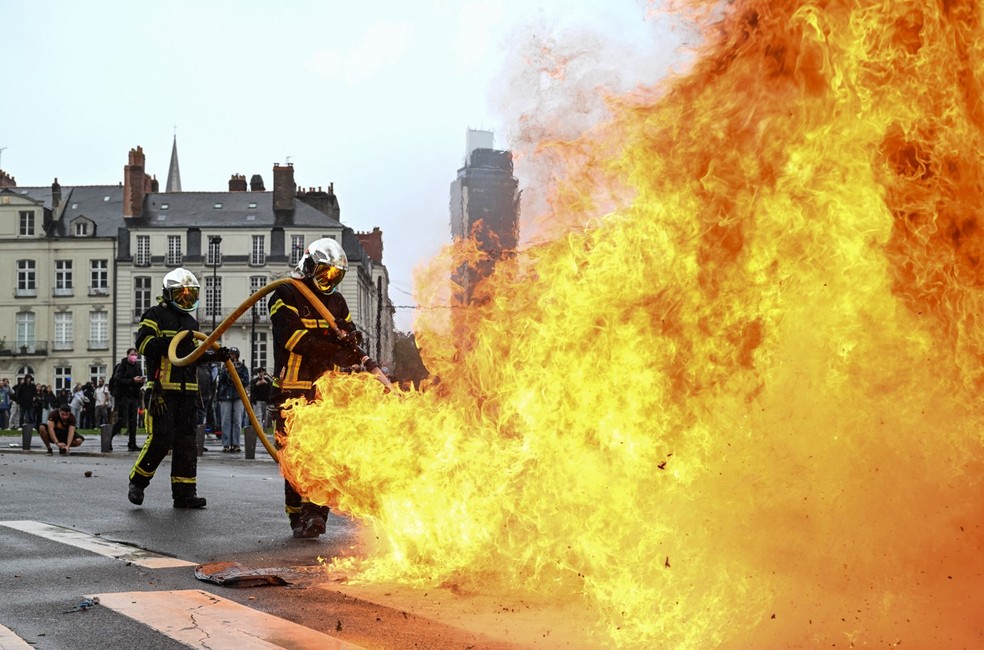 Bombeiros apagam incêndio em barricada durante manifestação do movimento de protesto "Bloquons tout" ("Vamos bloquear tudo"), em Nantes, oeste da França, em 10 de setembro de 2025. — Foto: Sebastien Salom-Gomis / AFP