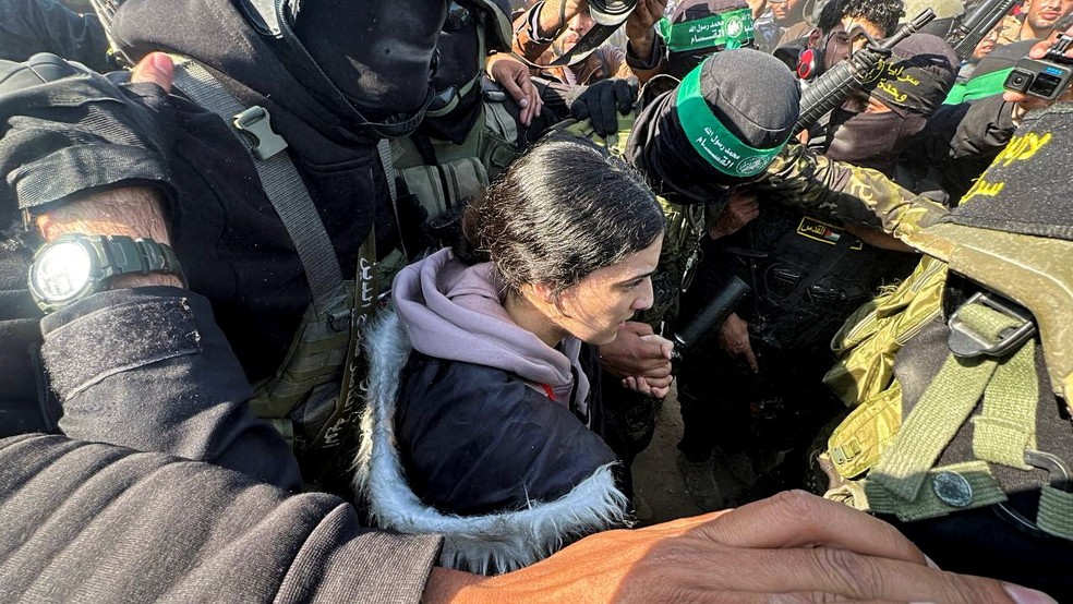 Refém israelense Arbel Yehud, de 29 anos, sendo conduzida por membros do grupo terrorista Hamas em meio a multidão durante libertação em 30 de janeiro de 2025. — Foto: REUTERS/Moaz Abu Taha