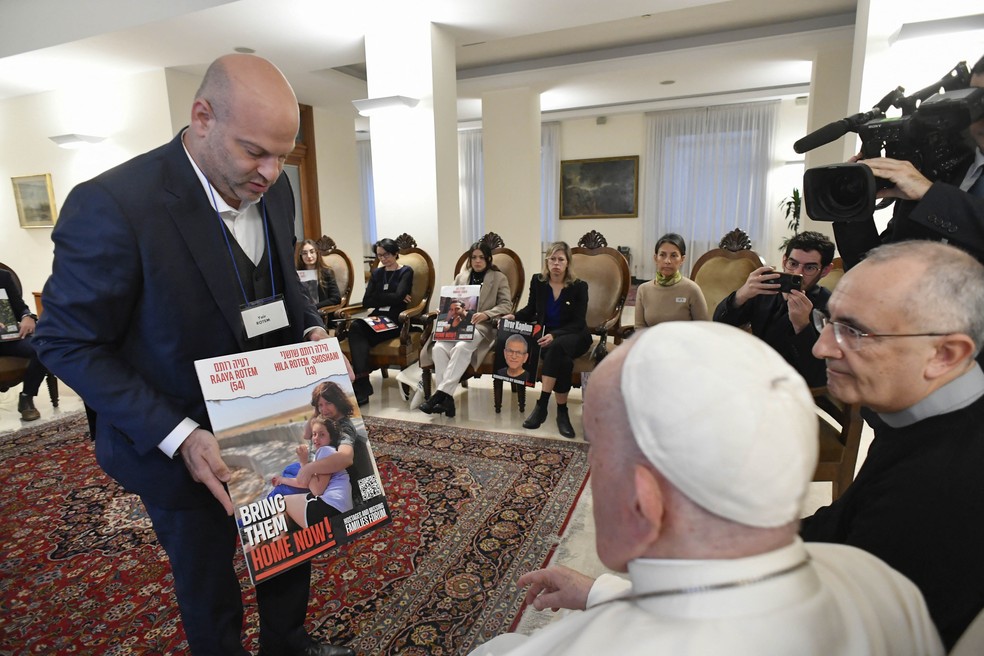 Papa Francisco observa foto de reféns do Hamas exibidas por um parente, em encontro com famílias de israelenses sequestrados pelo grupo terrorista no Vaticano, em 22 de novembro de 2023. — Foto: Vaticano via AFP