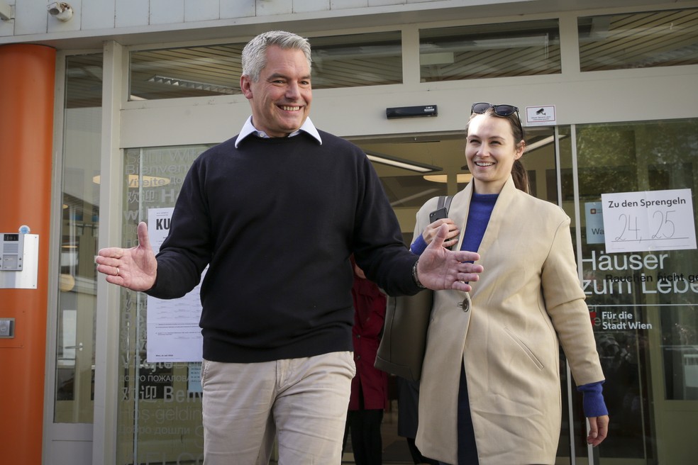 Karl Nehammer, atual chanceler da Áustria e líder do Partido Popular Austríaco (OVP), sorri saindo de um local de votação neste domingo (29). — Foto: AP Photo/Heinz-Peter Bader