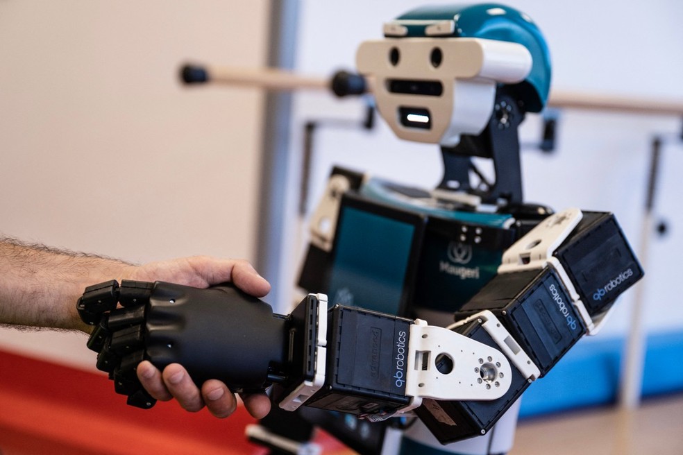 O rob&ocirc; humanoide Alter-Ego, projetado pelo Instituto Italiano de Tecnologia, cumprimenta um paciente no hospital IRCSS Maugeri, em Mil&atilde;o &mdash; Foto: MARCO BERTORELLO / AFP