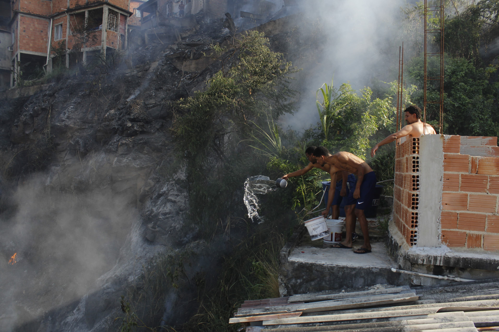 Moradores tentam controlar fogo no Complexo do Alemão — Foto: Uendel Vinícius/Jornal Voz das Comunidades