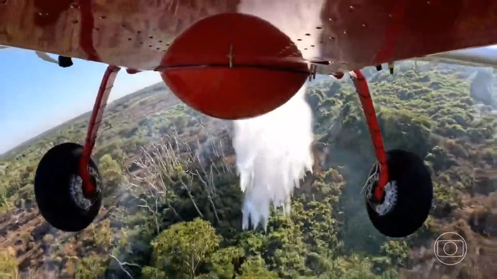 Avião usado pelo Corpo de Bombeiros liberando água para apagar o fogo no Pantanal — Foto: JN