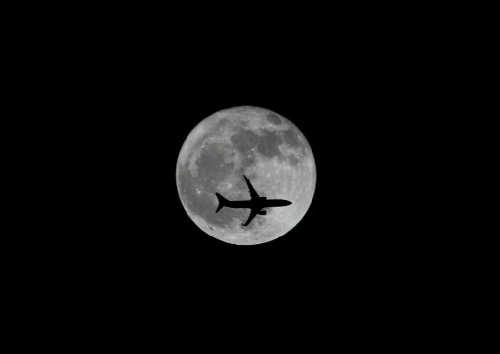 Avi&atilde;o passa pela Lua e imagem feita na cidade de Chennai, na &Iacute;ndia &mdash; Foto: P. Ravikumar/Reuters