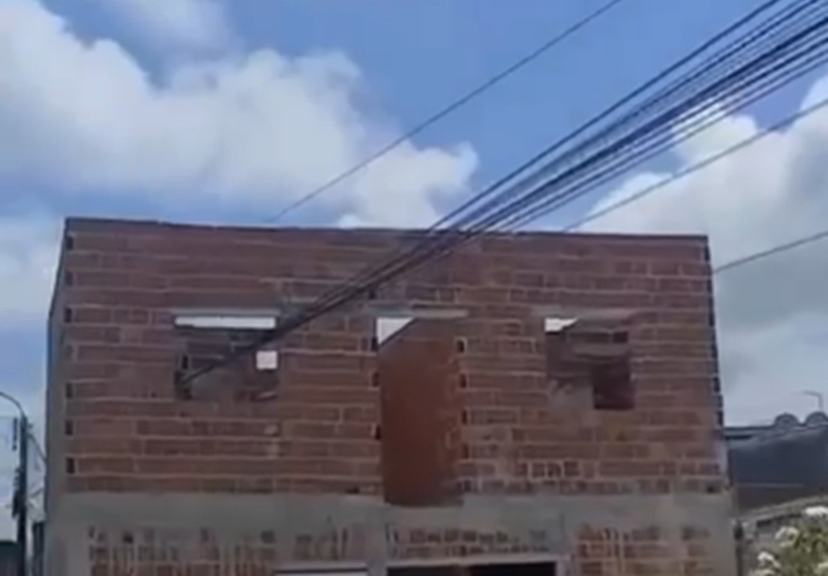 Laje de casa em construção é erguida ilegalmente em torno de fiação pública e imagem viraliza; VÍDEO