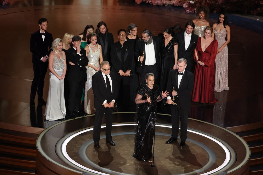 O diretor Christopher Nolan e os produtores Emma Thomas e Charles Roven discursam após vitória no Oscar 2024 na categoria de Melhor Filme com "Oppenheimer" — Foto: REUTERS/Mike Blake