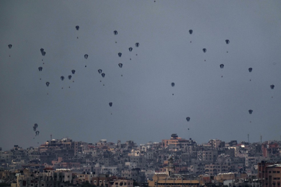 Paraquedas lançados com ajuda humanitária lançados em Gaza nesta sexta (8) — Foto: Leo Correa/AP