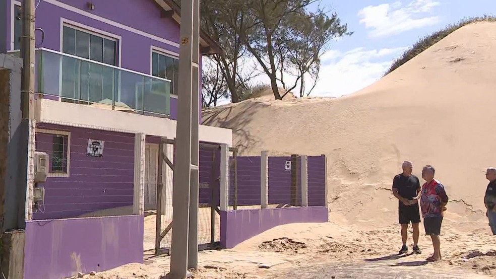 Dunas de areia estão cobrindo casa de moradores da Barra de Tramandaí, no Litoral Norte do RS — Foto: Reprodução/ RBS TV