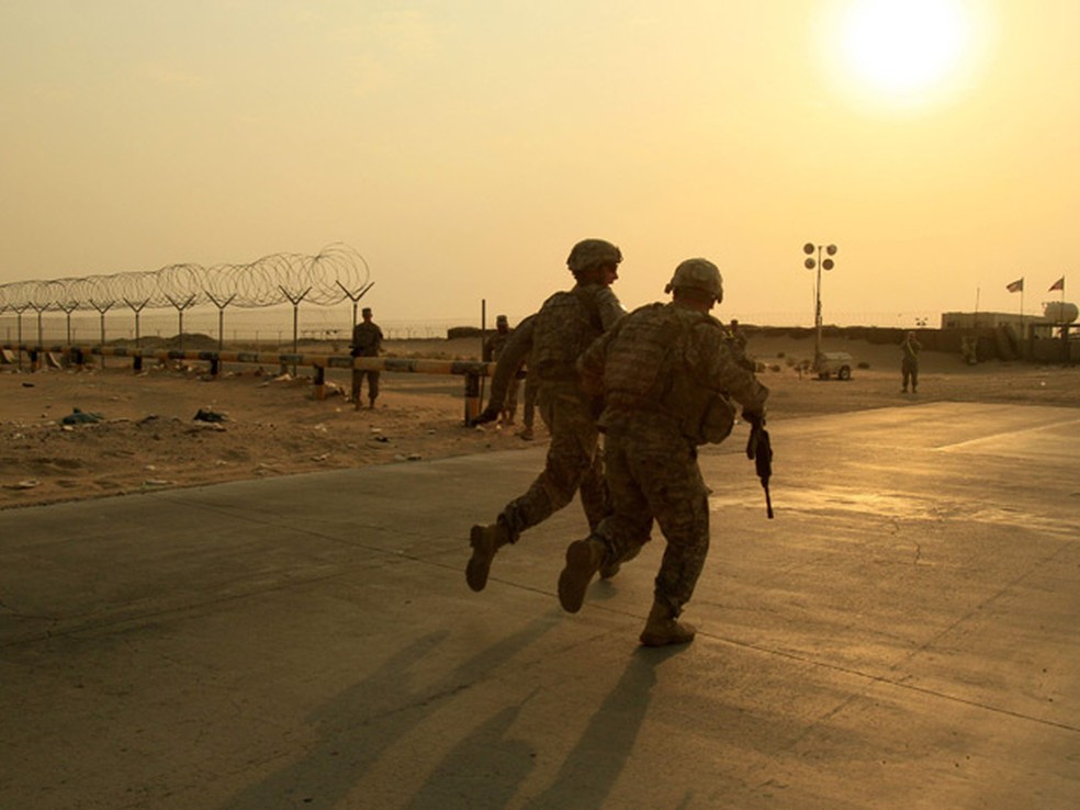 Militares do Exército americano correm em direção à fronteira do iraque com o Kwait, no último dia 18 de agosto — Foto: Maya Alleruzzo / AP