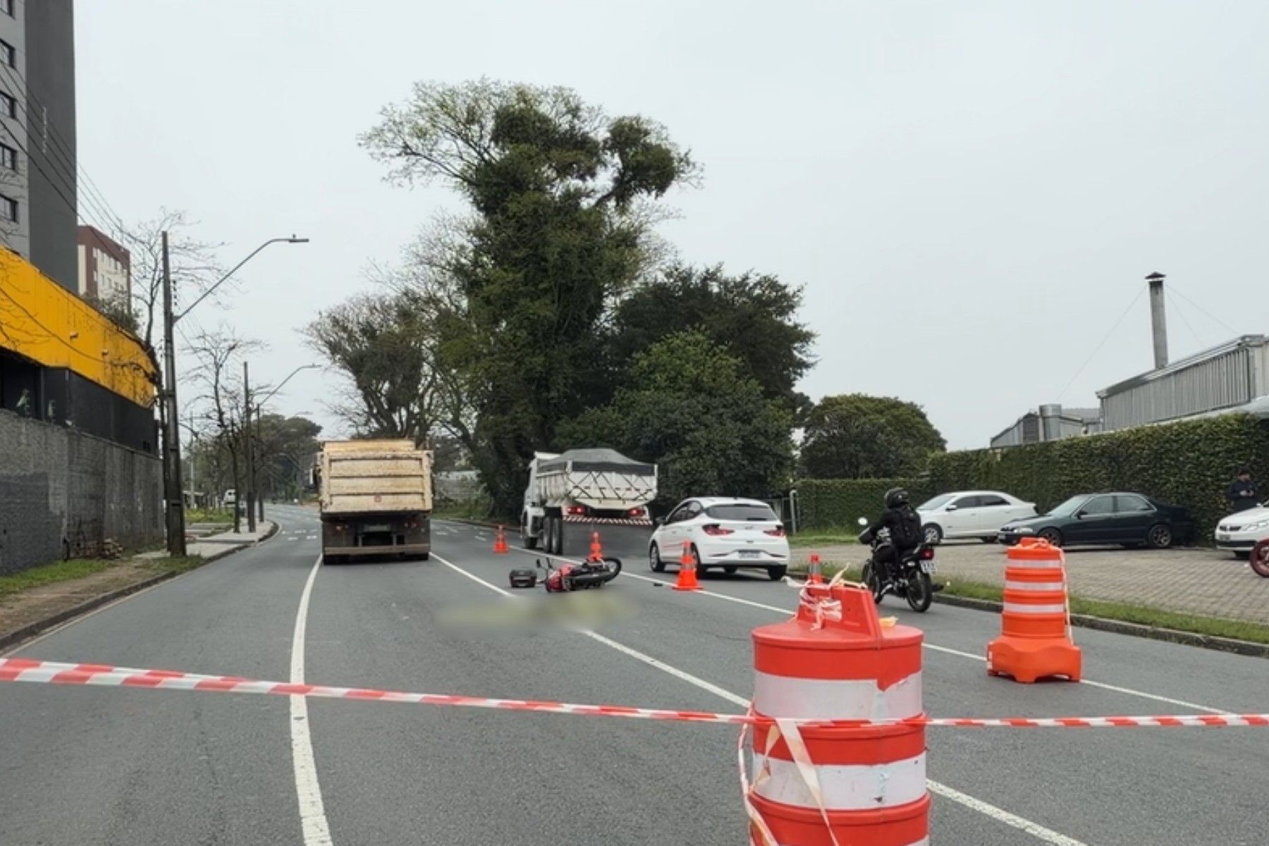 Motociclista atravessa cruzamento, bate em caminhão, para embaixo do rodado e morre atropelado em Curitiba