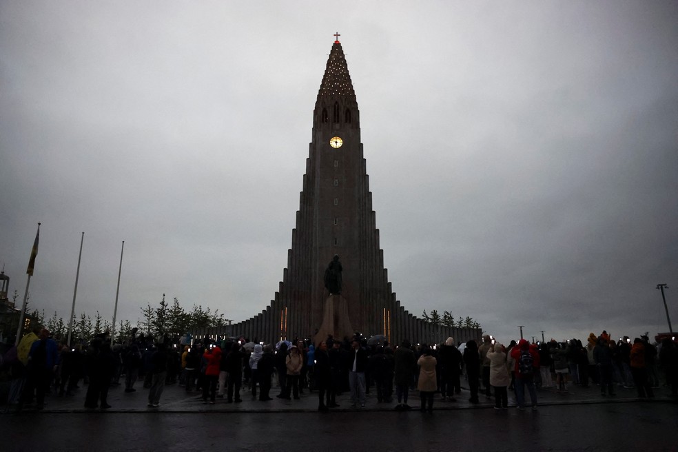 Pessoas se reúnem para observar o eclipse solar total, enquanto nuvens cobrem o céu, em Reykjavik, Islândia, em 12 de agosto de 2026 — Foto: Denis Balibouse/Reuters