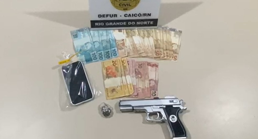 Arma e dinheiro apreendidos na operação — Foto: Reprodução