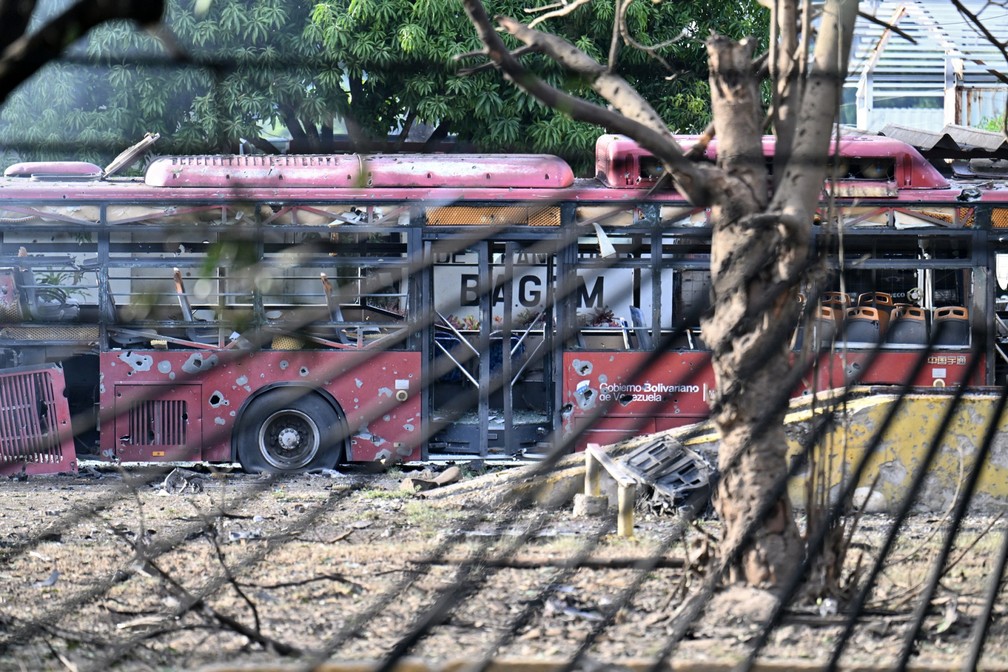 Vista de um ônibus destruído na base aérea de La Carlota, em Caracas. — Foto: JUAN BARRETO/AFP