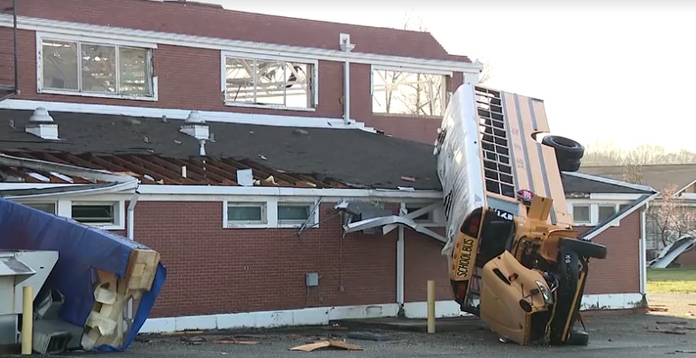 Ônibus escolar fica pendurado em telhado de escola após passagem de tornado no Alabama, nos Estados Unidos, em 15 de março de 2025. — Foto: Reprodução/WBMA via Reuters